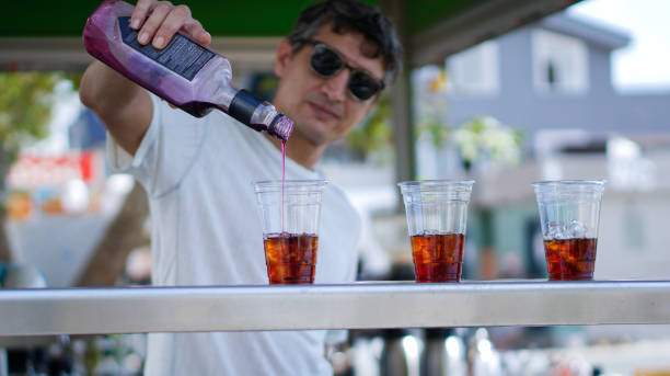 istock Bartender making and pouring alcoholic drink into the glasses 2175495501