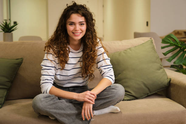 istock Happy young woman is relaxing on comfortable sofa at home 2175495642