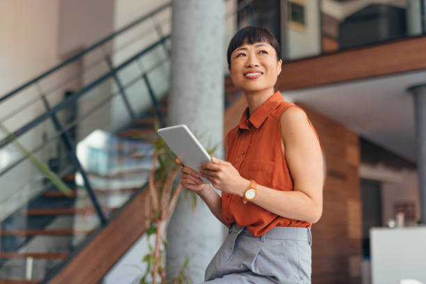 istock Smiling Japanese Professional Woman Using Tablet in Modern Office Setting 2175497222
