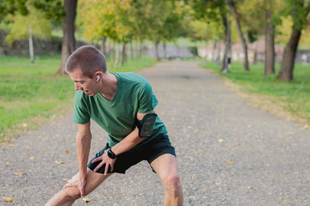 istock Happy athletic mid adult man doing gentle everyday exercise outdoors in public park, as part of his mental wellness and self-care activities. He is wearing sports clothes and smartwatch, and he is stretching after jogging. 2175498004