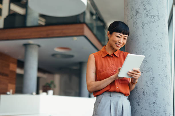 istock Smiling Japanese Professional Woman Using Tablet in Modern Office Setting 2175498597