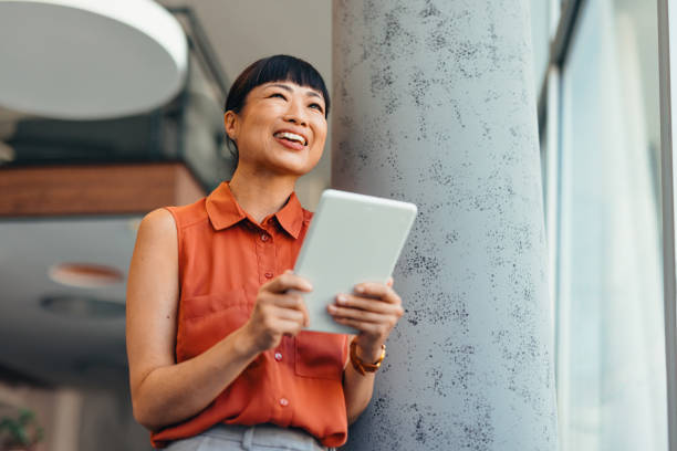 istock Smiling Japanese Professional Woman Using Tablet in Modern Office Setting 2175498820