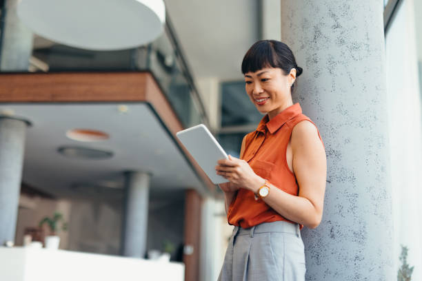istock Smiling Japanese Professional Woman Using Tablet in Modern Office Setting 2175498821