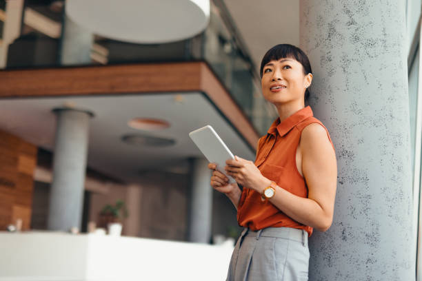 istock Smiling Japanese Professional Woman Using Tablet in Modern Office Setting 2175498824