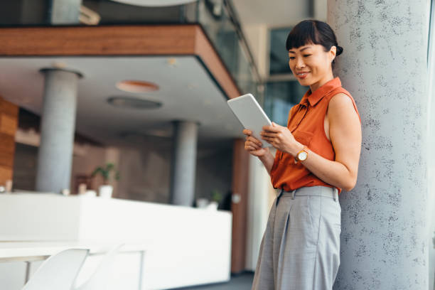 istock Smiling Japanese Professional Woman Using Tablet in Modern Office Setting 2175498829