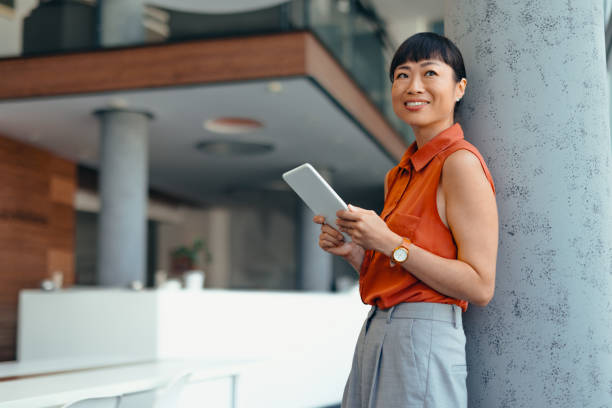 istock Smiling Japanese Professional Woman Using Tablet in Modern Office Setting 2175498898