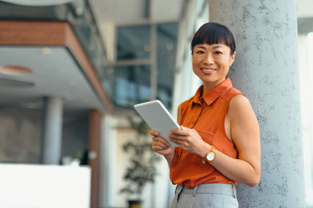 istock Smiling Japanese Professional Woman Using Tablet in Modern Office Setting 2175498903