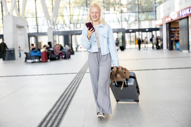 istock Traveler in terminal checking phone and heading onward 2175500267