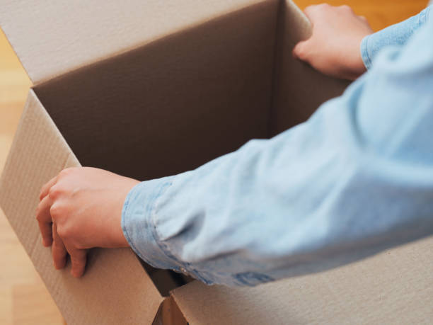 istock A person opening a cardboard box. Shallow depth of field. 2175509848