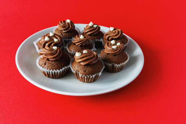 istock Mini chocolate cupcakes on a plate on a red background 2175510923