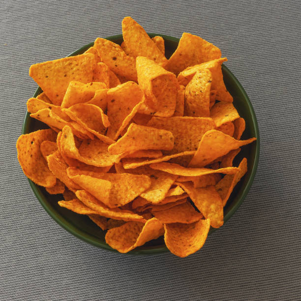 istock Cheese flavored corn chips in a green bowl on a tablecloth 2175511224
