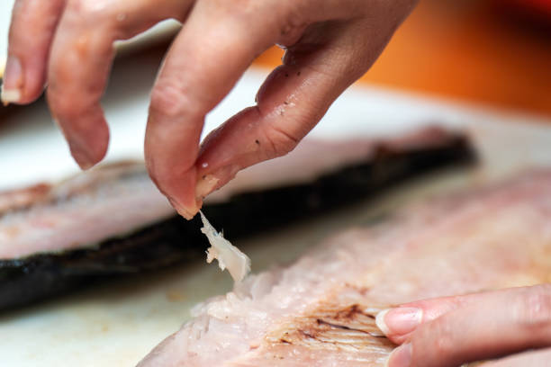 istock Delicate hands meticulously remove bones fresh salmon, transforming the raw fish into a pristine fillet. This process highlights culinary skill, precision, art of preparing high-quality ingredients 2175514353