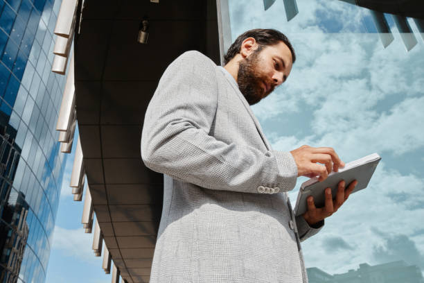 istock Businessman Using Tablet Near Modern Glass Building 2175515108