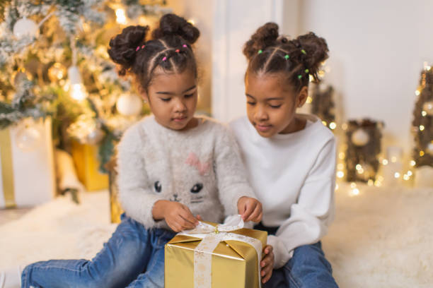 istock Girls open Christmas gifts. 2175515675