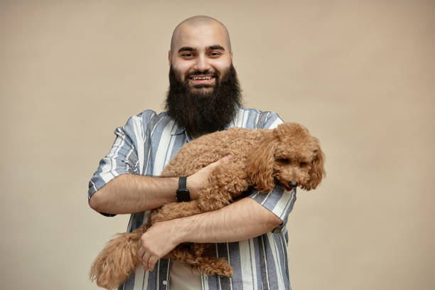 istock Man Holding Golden Poodle Smiling Happily at Camera 2175516429