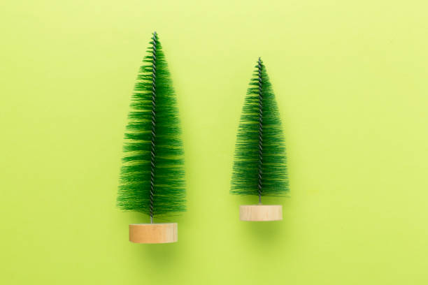 Small christmas tree with decor on color background, top view