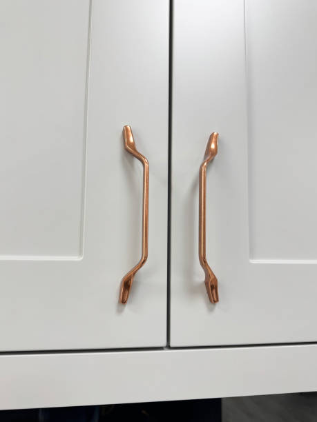 istock Image of modern white kitchen with wall cabinets and cupboards, featuring rose gold copper handles 2175522243