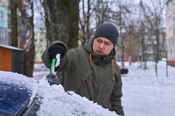 istock a man cleans the car window from snow 2175523578
