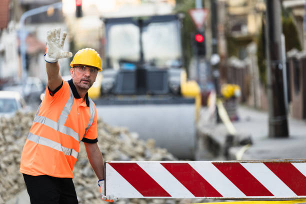 istock Construction worker directing traffic at a road work site in a busy urban area during daylight hours 2175524075