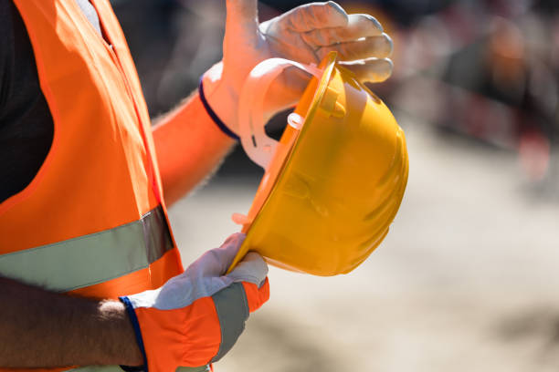 istock A construction worker prepares to wear a safety helmet at a work site, ensuring personal protection during the daytime activity 2175524082