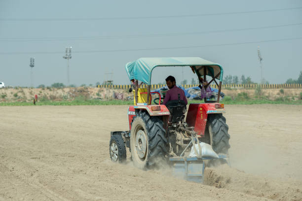 Ghaziabad, Uttar Pradesh, India- October 08 2020: An Indian farmer on a tractor prepares the field for the next crop.