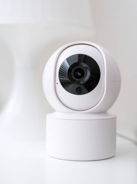 istock A white security camera with a black lens is mounted on a white surface. The camera is designed to capture images and record video footage 2175527898