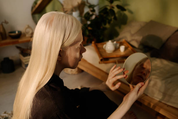 istock Young White-haired Woman Looking In Mirror 2175529858