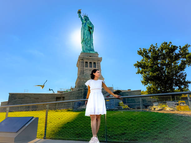 Woman taking picture with Statue of Liberty