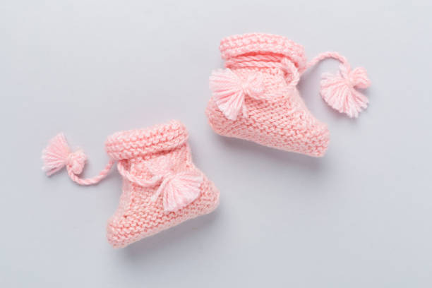 istock Pink baby booties on color background, top view 2175531570