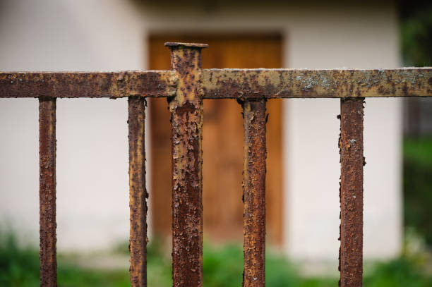 istock Rusty metal fence with green foliage background 2175531679