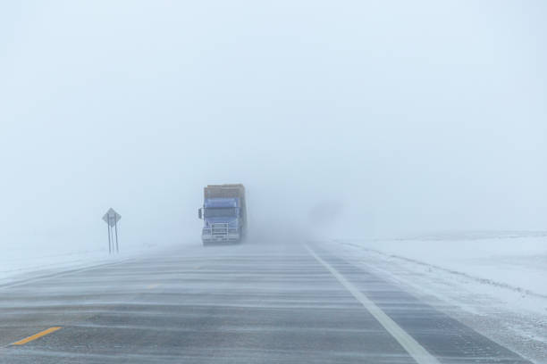 Wind blowing snow across the highway in winter creating limited visability.