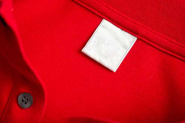 istock Blank white laundry care clothes label on red shirt fabric texture background 2175540802