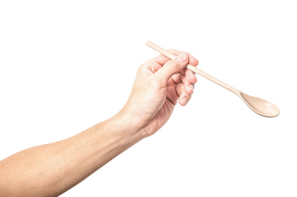 istock Male hand holding a brown plastic spoon isolated on white background. 2175549024