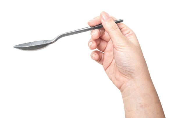 istock Female hand holding a black plastic spoon isolated on white background. 2175549037