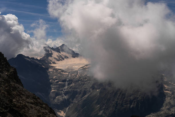 Cloud-Covered Mountain Peaks with Snow and Glacial Terrain