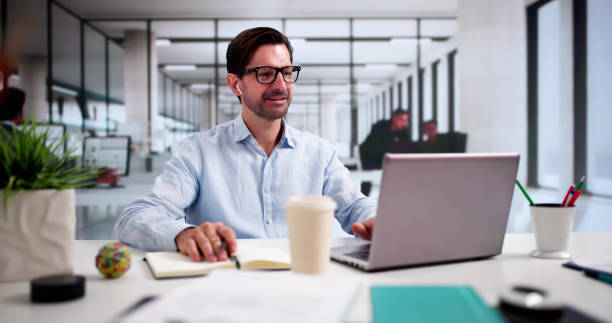 istock Man Studying Online On Laptop With Headphones 2175556676