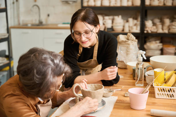 istock Old woman is making a clay bowl in a workshop 2175557623