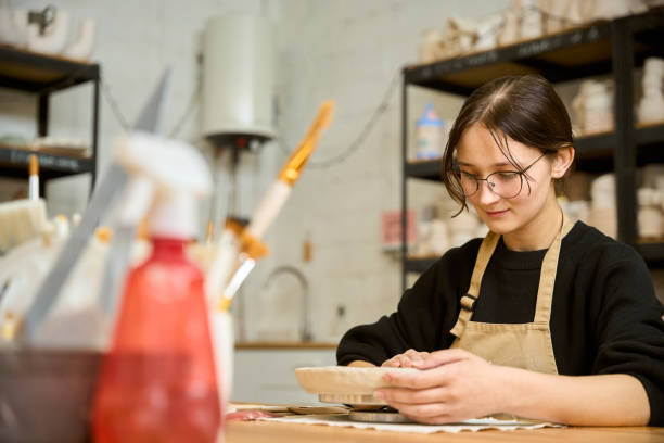 istock Young woman looking thoughtfully at clay sample 2175557636