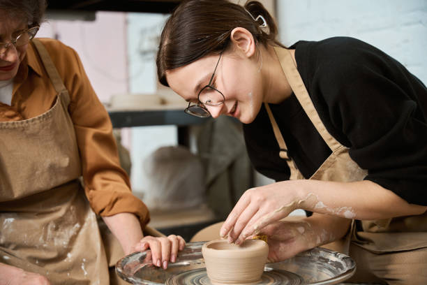 istock Craftswoman and elderly lady chatting while working in ceramics studio 2175557696