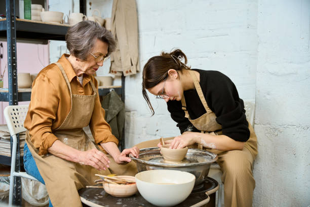 istock Young female in glasses works on pottery wheel 2175557698