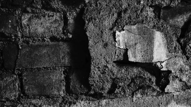 istock Abstract image of an old wall, broken plaster with old, partly broken bricks below, aged with long time. Black and white image of ageing, portrayed on an old wall. Howrah, West Bengal, India. 2175563356