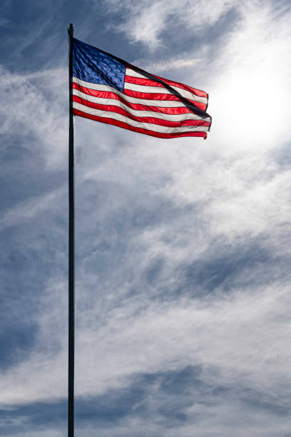 American flag backlit against a sunny sky, USA