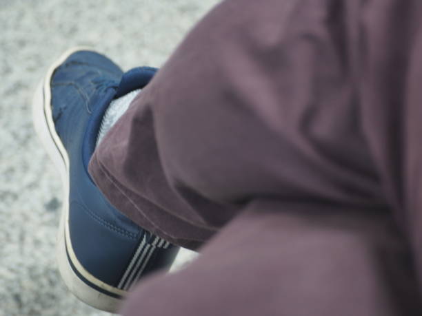 Shoes, pants, gray and black color and sole, white light used as background.