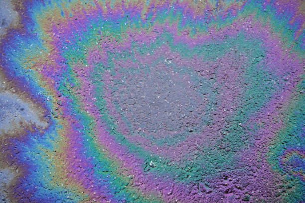 istock multicolored gasoline oil stain on the asphalt road surface texture. environmental pollution. 2175565202