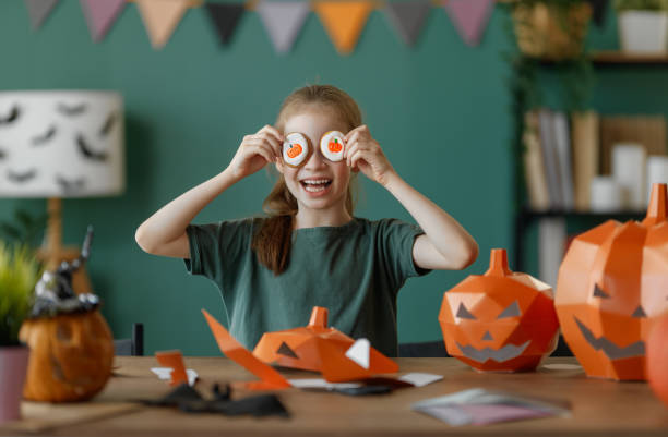 istock girl with polygonal paper pumpkin 2175569760