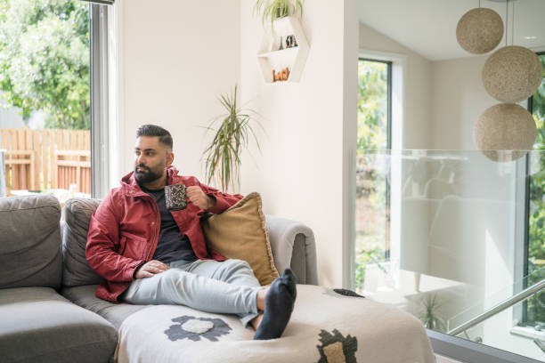 istock Handsome  man resting on couch with cup of coffee. 2175569856