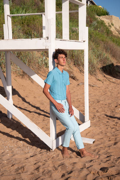 istock A young attractive guy is walking on the beach. 2175570661