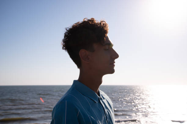 istock A young attractive guy is walking on the beach. 2175570783
