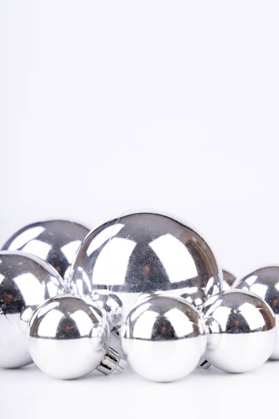 istock Shiny silver Christmas balls of various sizes used as decorations on a white background, arranged in an elegant festive setting 2175575687