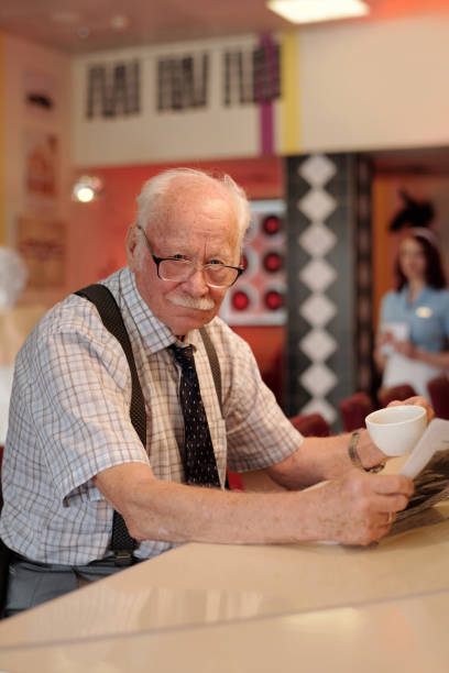 istock Engaging Elderly Man Enjoying Coffee at Cozy Cafe Counter 2175576186